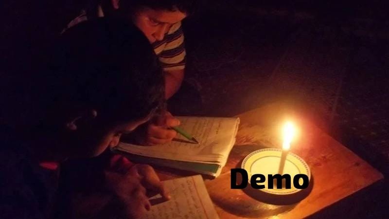 Girl studying by candlelight during a power cut