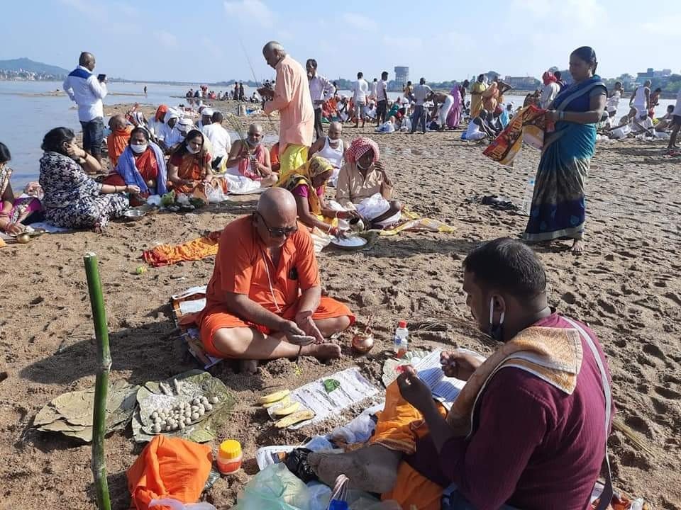 Devotees in saffron clothes performing pind daan rituals during Pitru Paksha